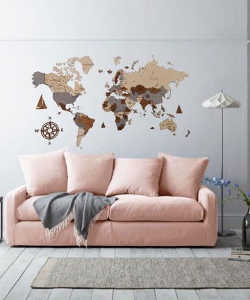 drewniana mapa świata nad różową kanapą